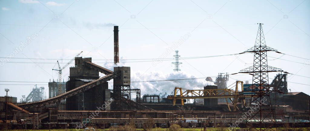 The plant emits pollutants into the atmosphere, from the factory pipes comes out a thick smoke. Industry metallurgical plant. Environmental disaster and the smoke.