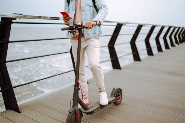 Jovem Com Telefone Montando Scooter Elétrico Cais Perto Mar Conceito — Fotografia de Stock