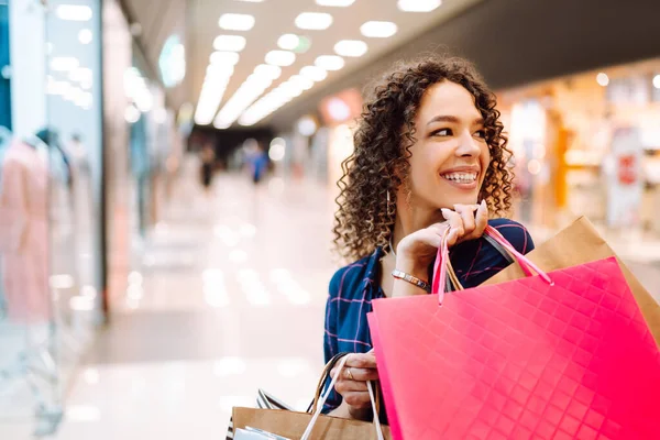 Alışveriş zamanı. Alışveriş merkezinden sonra genç bir kadın. Tüketim, satış, alım-satım, yaşam tarzı kavramı.