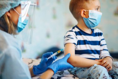 Aşı olan çocuk evde. Covid-19 koronavirüs aşısı, grip, bulaşıcı hastalıklar. Tıp, sağlık ve salgın konsepti.