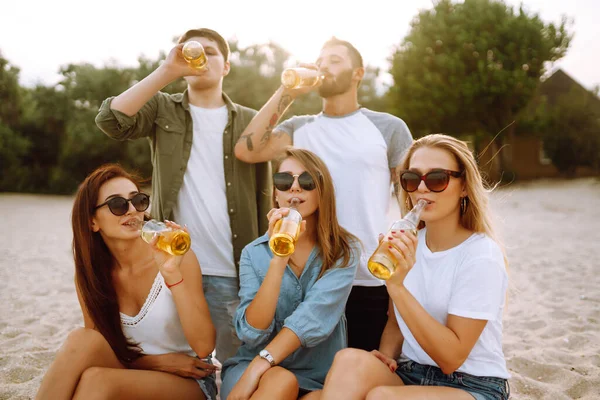 Los Jóvenes Amigos Sosteniendo Botellas Con Cerveza Fiesta Playa Grupo —  Fotos de Stock