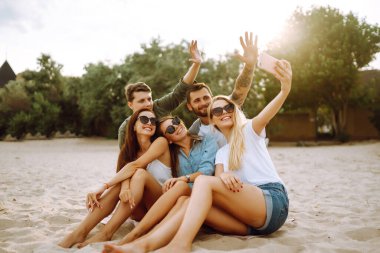 Selfie zamanı. Bir grup arkadaş telefonla selfie çekiyor. Genç arkadaşlar plajda birlikte yaz partisinin tadını çıkarıyorlar. Arkadaşlık ve yaşam tarzı kavramları.