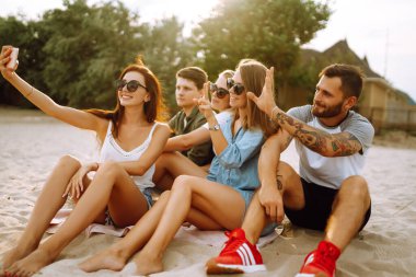Selfie zamanı. Bir grup arkadaş telefonla selfie çekiyor. Genç arkadaşlar plajda birlikte yaz partisinin tadını çıkarıyorlar. Arkadaşlık ve yaşam tarzı kavramları.