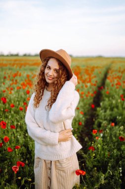 Gelincik tarlasında güzel bir kadın. İnsanlar, yaşam tarzı, seyahat, doğa ve tatil kavramı.