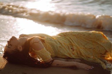 Gün batımında sahilde güzel bir kadın. Seyahat tatili boyunca açık havada huzurlu okyanus doğasının tadını çıkarıyor. Yaz zamanı..