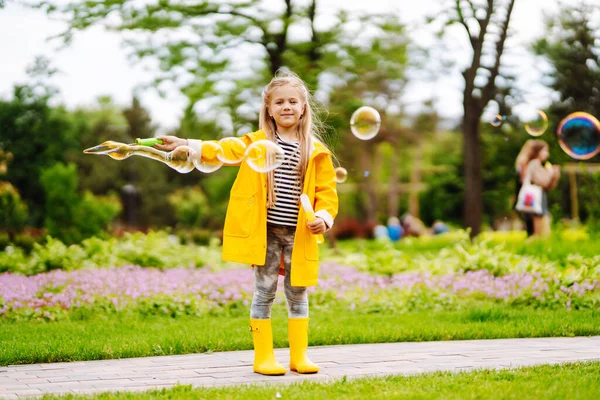 夏天公园里一个可爱的小女孩在外面吹肥皂泡 快乐童年的概念 — 图库照片