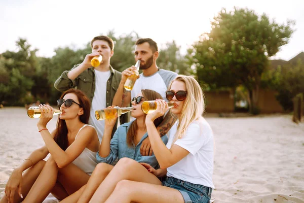 Grupa Przyjaciół Wiwatuje Pije Piwo Plaży Młodzi Przyjaciele Siedzą Razem — Zdjęcie stockowe
