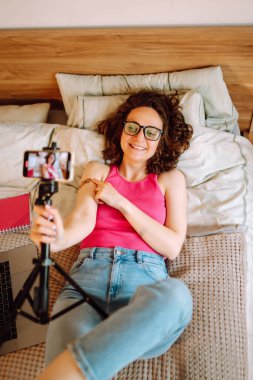 İnsanların bağışıklık sistemi için aşı konsepti. Kadın blogcu, video blogunu evde kaydediyor ve covid-19 aşısı hakkında konuşuyor. Sosyal medya ve karantina. Sağlık, koronavirüs, önleme.