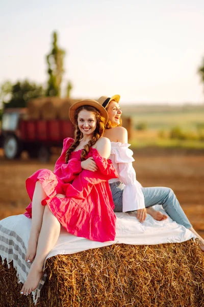 Två Unga Kvinnor Moderiktiga Och Stilrena Kläder Poserar Nära Höbalar — Stockfoto