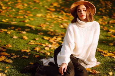 Parkta sonbahar havasının tadını çıkaran şık bir kadın. Moda, tarz kavramı.