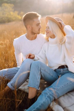 Genç çift sonbahar güneşli günlerinde yürüyüş ve kucaklaşma yaparken eğleniyor. Birlikte eğleniyoruz. Gençlik, aşk ve yaşam tarzı kavramı.