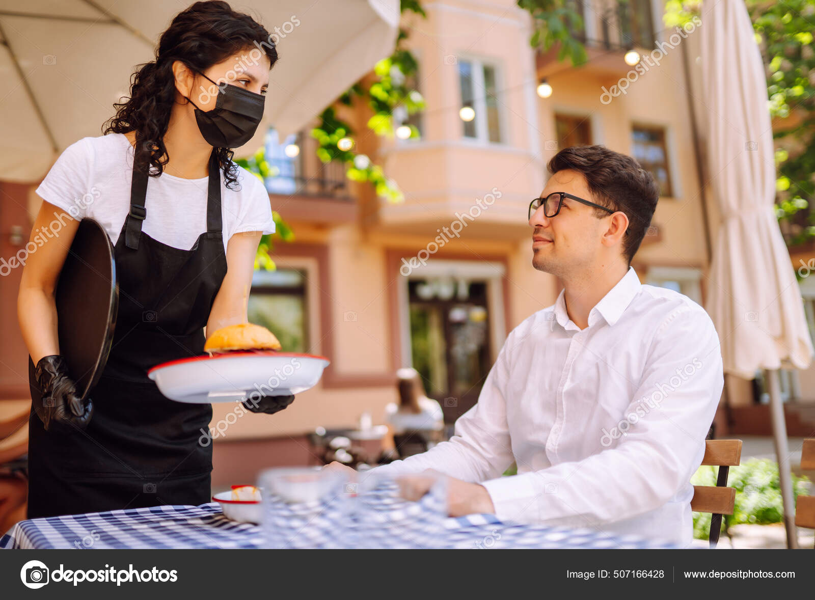 Garçonete De Restaurante Servindo Mesa Com Comida Imagem de Stock