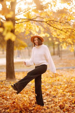 Parkta gezen, şık şapkalı genç bir kadının güneşli bir hayat tarzı portresi. Moda, tarz kavramı. İnsanlar, rahatlama ve tatil kavramı.