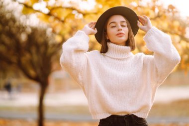 Parkta gezen, şık şapkalı genç bir kadının güneşli bir hayat tarzı portresi. Moda, tarz kavramı. İnsanlar, rahatlama ve tatil kavramı.