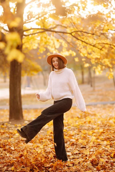 Parkta gezen, şık şapkalı genç bir kadının güneşli bir hayat tarzı portresi. Moda, tarz kavramı. İnsanlar, rahatlama ve tatil kavramı.