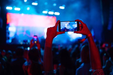 Canlı müzik festivalinde akıllı telefon kayıtları, konser sahnesinin, canlı konserin fotoğrafını çekmek. Gençlik, parti, tatil konsepti.