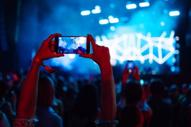 Canlı müzik festivalinde akıllı telefon kayıtları, konser sahnesinin, canlı konserin fotoğrafını çekmek. Gençlik, parti, tatil konsepti.
