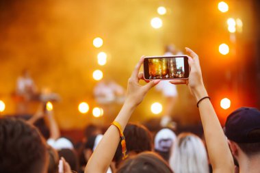 Canlı müzik festivalinde akıllı telefon kayıtları, konser sahnesinin, canlı konserin fotoğrafını çekmek. Gençlik, parti, tatil konsepti.