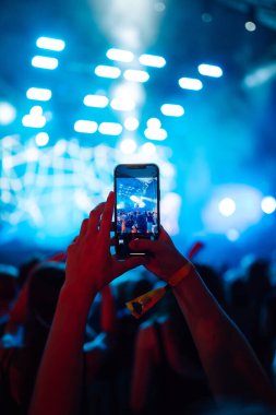 Canlı müzik festivalinde akıllı telefon kayıtları, konser sahnesinin, canlı konserin fotoğrafını çekmek. Gençlik, parti, tatil konsepti.