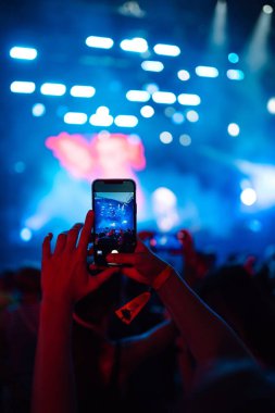 Canlı müzik festivalinde akıllı telefon kayıtları, konser sahnesinin, canlı konserin fotoğrafını çekmek. Gençlik, parti, tatil konsepti.