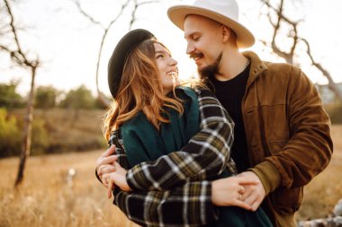 Sonbahar parkında yürüyen romantik bir çift. Aşk hikayesi. Sonbahar tarzı. Öp ve sarıl..