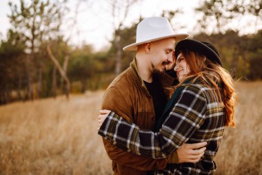 Sonbahar parkında yürüyen romantik bir çift. Aşk hikayesi. Sonbahar tarzı. Öp ve sarıl..