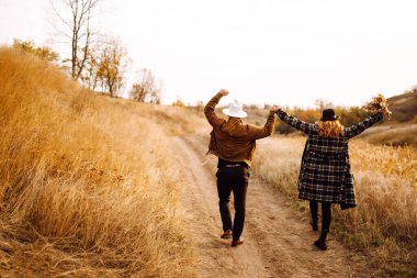 Sonbahar parkında yürüyen romantik bir çift. Aşk hikayesi. Sonbahar tarzı. Öp ve sarıl..