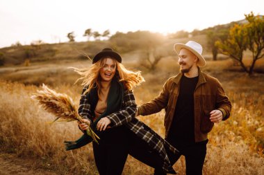 Sonbahar parkında yürüyen romantik bir çift. Aşk hikayesi. Sonbahar tarzı. Öp ve sarıl..