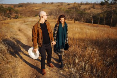 Sonbahar parkında yürüyen romantik bir çift. Aşk hikayesi. Sonbahar tarzı. Öp ve sarıl..