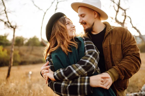Sonbahar parkında yürüyen romantik bir çift. Aşk hikayesi. Sonbahar tarzı. Öp ve sarıl..