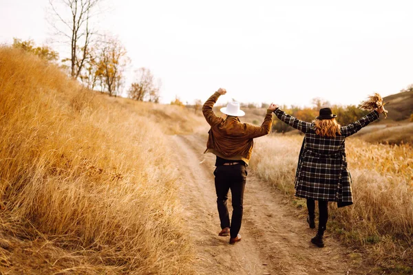 Sonbahar parkında yürüyen romantik bir çift. Aşk hikayesi. Sonbahar tarzı. Öp ve sarıl..