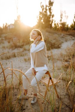 Doğada poz veren zarif, lüks bir kadının portresi. İnsanlar, yaşam tarzı, rahatlama ve tatil konsepti. Moda, tarz kavramı. 