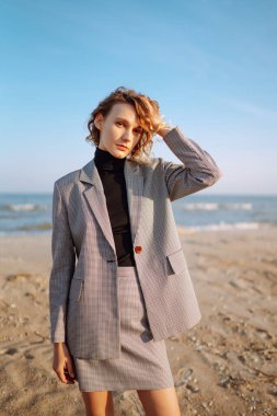 Moda Modeli deniz kenarında poz veriyor. Doğada dinlenen genç bir kadın. İnsanlar, yaşam tarzı, rahatlama ve tatil konsepti. Moda, tarz kavramı. 