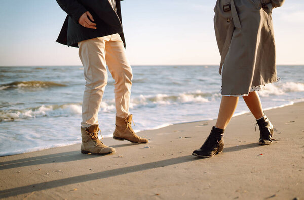 Модная пара наслаждается друг другом на пляже в осенний солнечный день. Путешествия, выходные, отдых и образ жизни. 