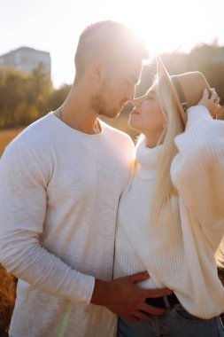 Sonbahar güneşli günlerinde aşık romantik bir çift yürüyor. Aşk hikayesi. Sonbahar tarzı. Öp ve sarıl..