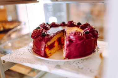 A transparent display case full of various sweets in cozy coffee shop. Freshly baked cinnamon rolls and delicious pie in bakery. A cozy atmosphere. Concept is consumerism, small business, and food.
