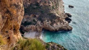 Uçurumlar arasında gizlenmiş, kristal berrak sular ve yumuşak kumun bulunduğu, rahatlamak ve doğanın güzelliğinin tadını çıkarmak için mükemmel bir kumsal keşfedin..