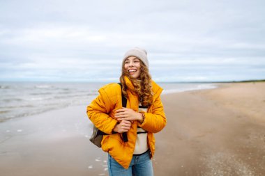 Parlak ceketli bir gezgin bulutlu bir günde kumlu bir plaj boyunca yürür. Güzel bir kadın dışarıda eğleniyor, deniz manzarasının tadını çıkarıyor. Konsept macera, eğlence ve özgürlük..