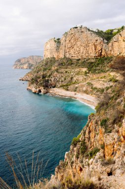 Deniz Burnu. Sakin turkuaz suları olan kayalık kayalıklar. Kıyı manzarası. Etrafı canlı denizlerle çevrili tenha bir körfez. Doğa konsepti.