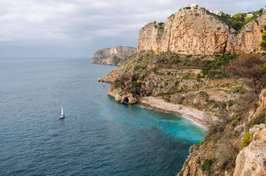 Deniz Burnu. Sakin turkuaz suları olan kayalık kayalıklar. Kıyı manzarası. Etrafı canlı denizlerle çevrili tenha bir körfez. Doğa konsepti.