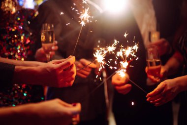 Ellerinde pırıl pırıl parlıyor. Bir grup mutlu insan havai fişeklerle eğleniyor. Kış tatili.