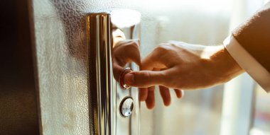 Yakın plan. Bir insan parmağı asansör düğmesine basar. Kapalı mekanda bir erkek eli. Kırmızı bir düğme. Teknoloji kavramı.