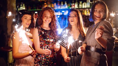 Şık kıyafetler içindeki mutlu kadınlar rahat bir odada, kadeh tokuşturup kıvılcımlar yakarak eğleniyorlar. Dört kız arkadaş gözlüklü ve maytaplı tatilin tadını çıkarıyor. Konsept rahat ve eğlenceli..