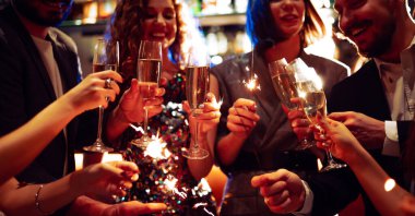 Mutlu bir grup barda eğleniyor, içki içiyor ve rahat bir yerde maytap yakıyor. Genç erkekler ve bir kadın kutlama yapıyor ve barda eğleniyorlar. Parti kavramı, kutlama..