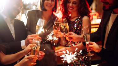 Mutlu bir grup barda eğleniyor, içki içiyor ve rahat bir yerde maytap yakıyor. Genç erkekler ve bir kadın kutlama yapıyor ve barda eğleniyorlar. Parti kavramı, kutlama..