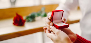 Aşık bir adam yüzük kutusunu tutar ve kız arkadaşına evlenme teklif eder. Genç bir çift yıldönümlerini bir kafede buluşarak kutluyor. Konsept: Tatil, aşkım. Sevgililer Günü.