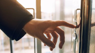 Asansör düğmesine basan. Parmak asansör düğmesine basar. Kırmızı düğme. gün batımı ışığı.