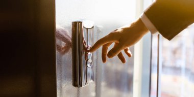 Asansör düğmesine basan. Parmak asansör düğmesine basar. Kırmızı düğme. gün batımı ışığı.