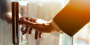 Asansör düğmesine basan. Parmak asansör düğmesine basar. Kırmızı düğme. gün batımı ışığı.