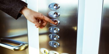 Asansör düğmesine basan. Parmak asansör düğmesine basar. Kırmızı düğme. gün batımı ışığı.